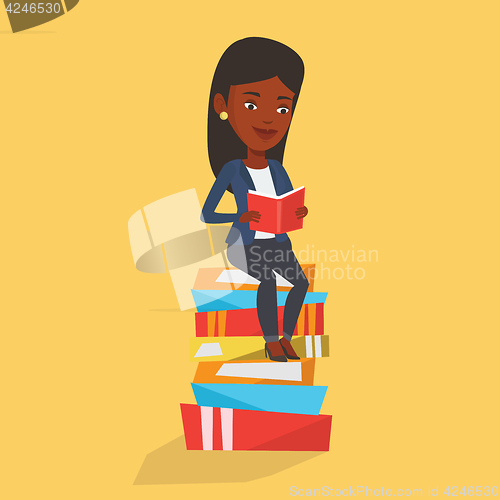 Image of Student sitting on huge pile of books.