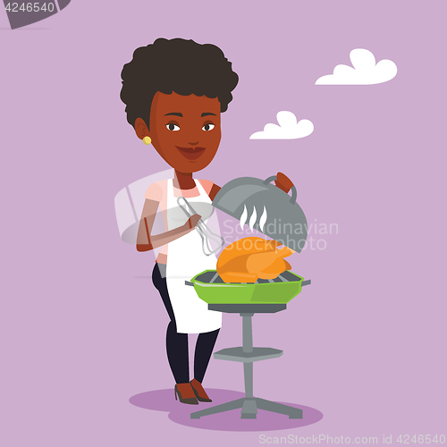 Image of Woman cooking chicken on barbecue grill.