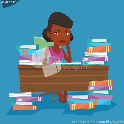 Image of Student sitting at the table with piles of books.