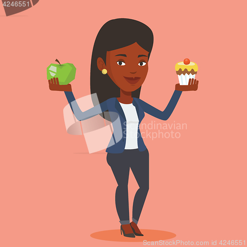 Image of Woman choosing between apple and cupcake.