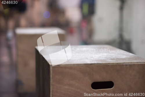 Image of black woman is performing box jumps at gym