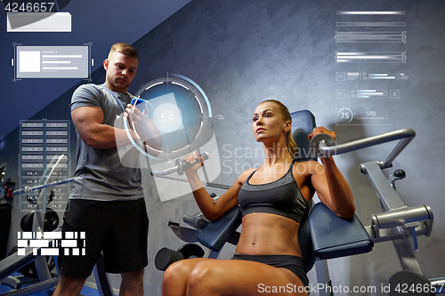 Image of man and woman flexing muscles on gym machine