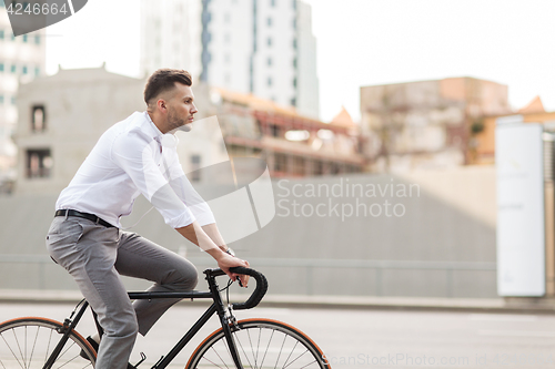 Image of man with headphones riding bicycle on city street