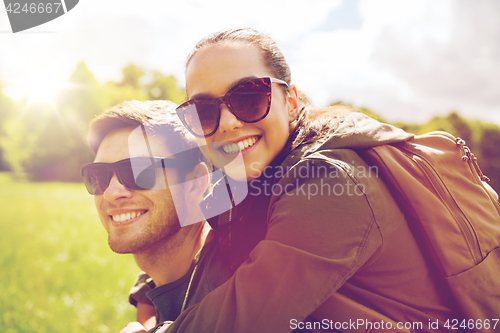 Image of happy couple with backpacks having fun outdoors