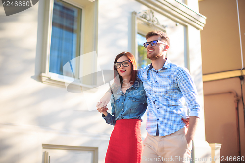 Image of Happy young couple standing at street of city and laughing on the bright sunny day