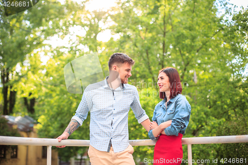 Image of Happy young couple at park standing and laughing on the bright sunny day