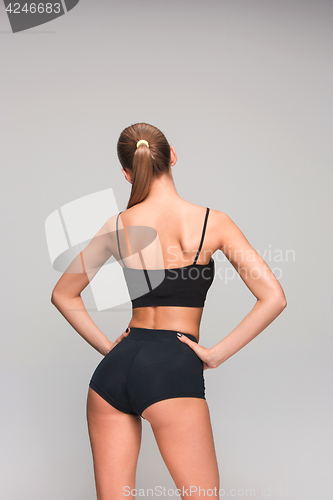 Image of Muscular young woman athlete on gray