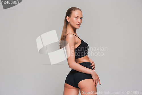 Image of Muscular young woman athlete on gray