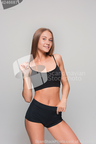 Image of Muscular young woman athlete on gray