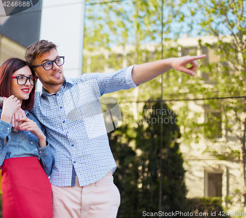 Image of Happy young couple standing at street of city and laughing on the bright sunny day