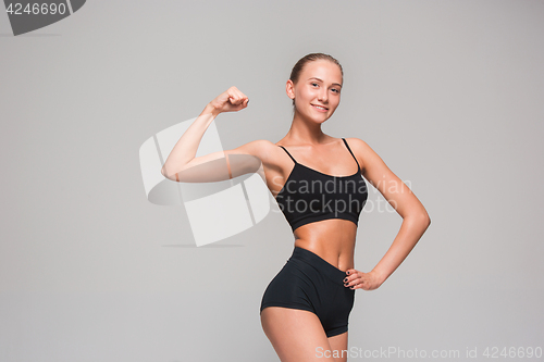 Image of Muscular young woman athlete on gray