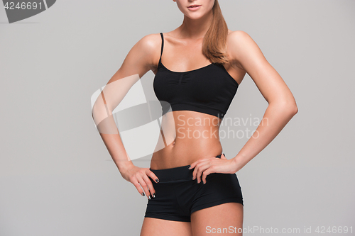 Image of Muscular young woman athlete on gray