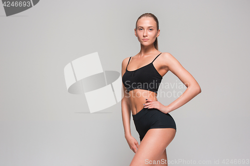 Image of Muscular young woman athlete on gray