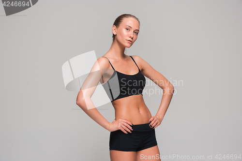 Image of Muscular young woman athlete on gray