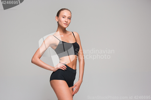 Image of Muscular young woman athlete on gray