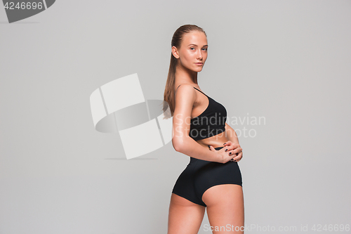 Image of Muscular young woman athlete on gray