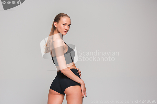 Image of Muscular young woman athlete on gray
