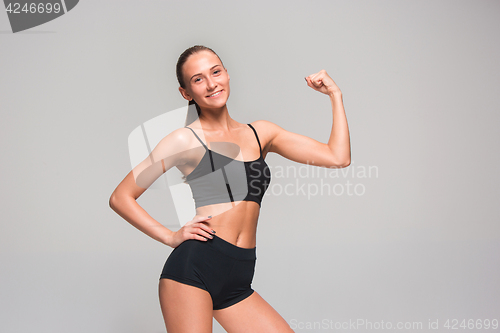 Image of Muscular young woman athlete on gray