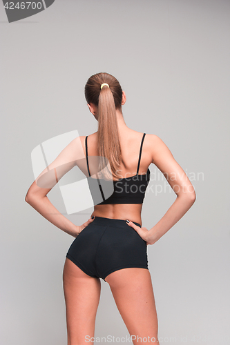 Image of Muscular young woman athlete on gray