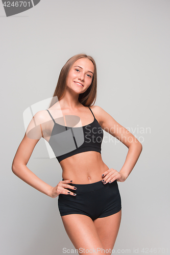Image of Muscular young woman athlete on gray