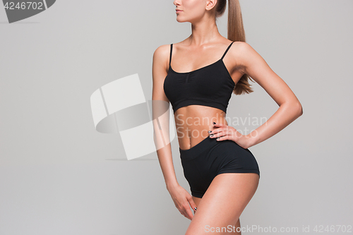 Image of Muscular young woman athlete on gray