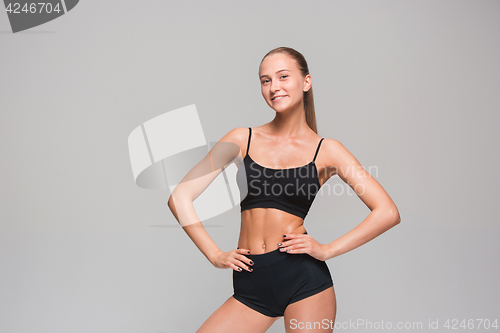 Image of Muscular young woman athlete on gray