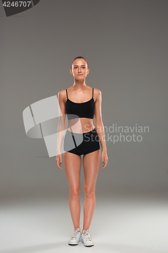 Image of Muscular young woman athlete on gray