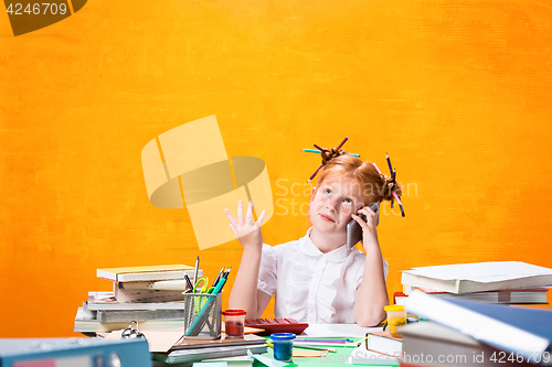 Image of The Redhead teen girl with lot of books at home. Studio shot