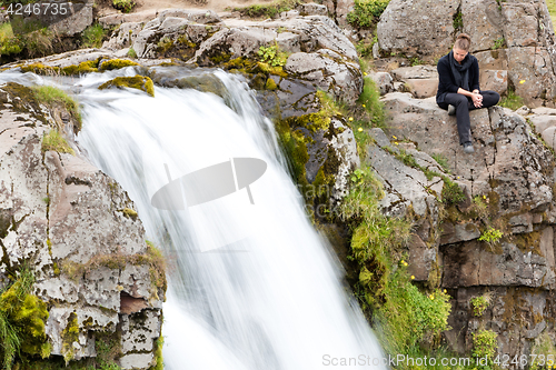 Image of Woman at Kirkjufellsfoss waterfall near the Kirkjufell mountain