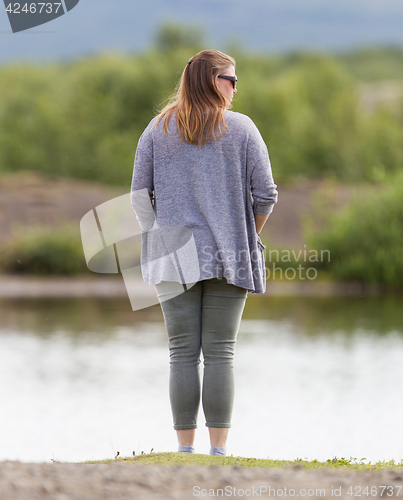 Image of Woman standing at the riverside