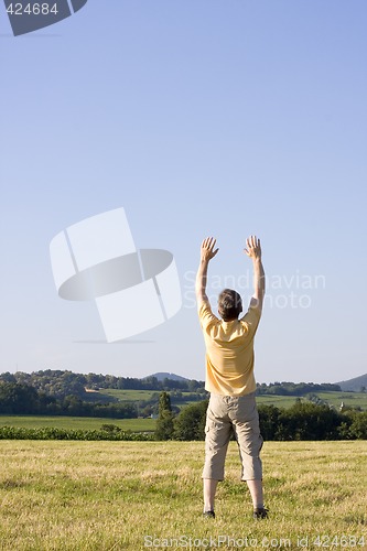 Image of Man with uplifted arms in a meadow