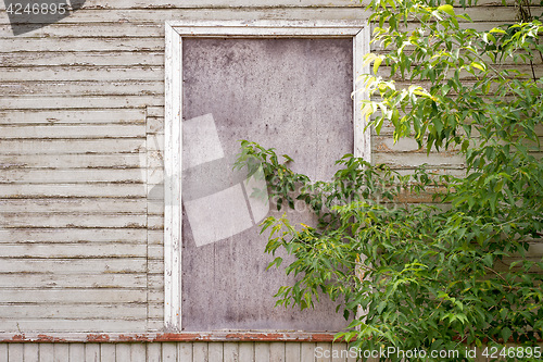 Image of abandoned wooden house with boarded up windows