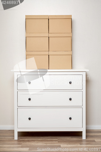 Image of Cardboard boxes on white wooden commode