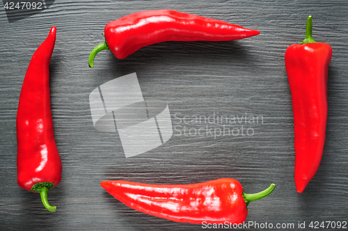 Image of Frame made of sweet red Kapia peppers on a dark shale