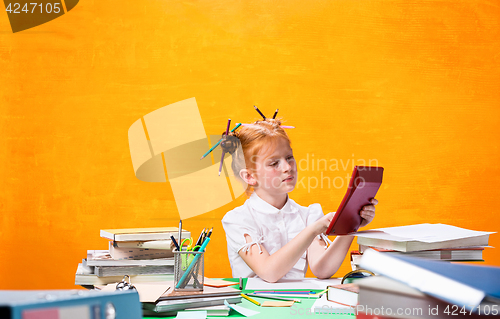 Image of The Redhead teen girl with lot of books at home. Studio shot