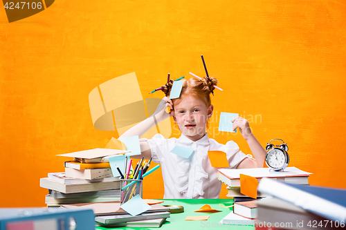 Image of The Redhead teen girl with lot of books at home. Studio shot