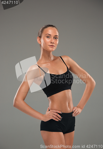 Image of Muscular young woman athlete on gray