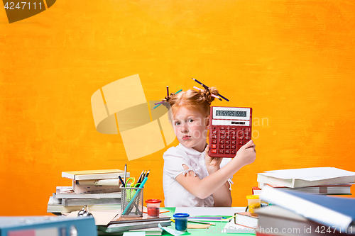 Image of The Redhead teen girl with lot of books at home. Studio shot