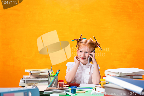 Image of The Redhead teen girl with lot of books at home. Studio shot