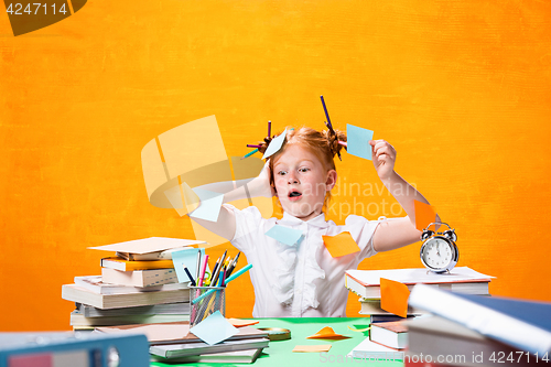 Image of The Redhead teen girl with lot of books at home. Studio shot