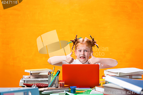 Image of The Redhead teen girl with lot of books at home. Studio shot