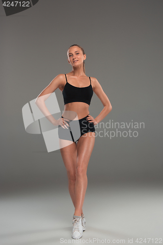 Image of Muscular young woman athlete on gray
