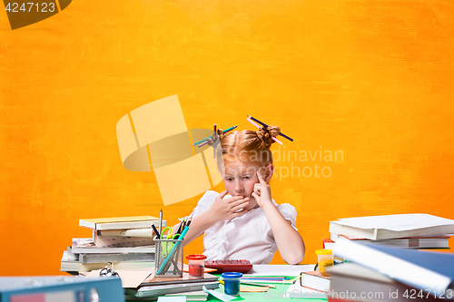 Image of The Redhead teen girl with lot of books at home. Studio shot