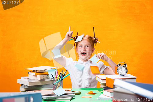 Image of The Redhead teen girl with lot of books at home. Studio shot
