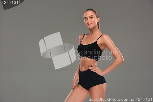 Image of Muscular young woman athlete on gray