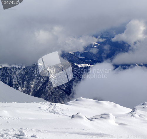 Image of View on winter snowy mountains in clouds