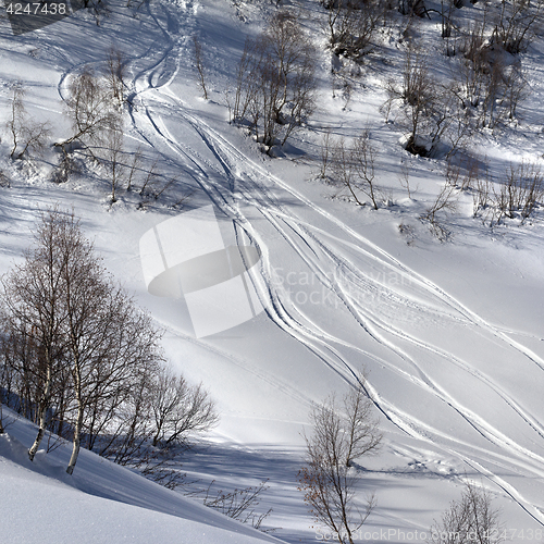 Image of Off-piste slope with track from ski and snowboard in sun day