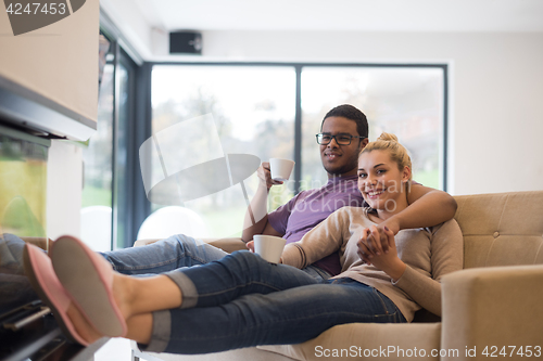 Image of Young multiethnic couple  in front of fireplace