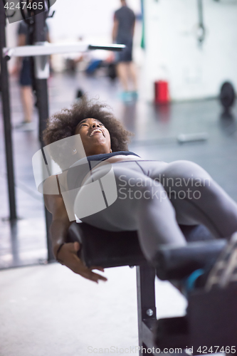 Image of black woman doing sit ups at the gym