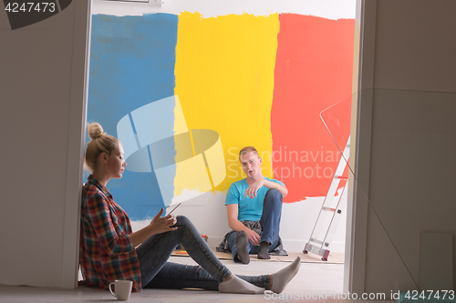 Image of Happy young couple relaxing after painting